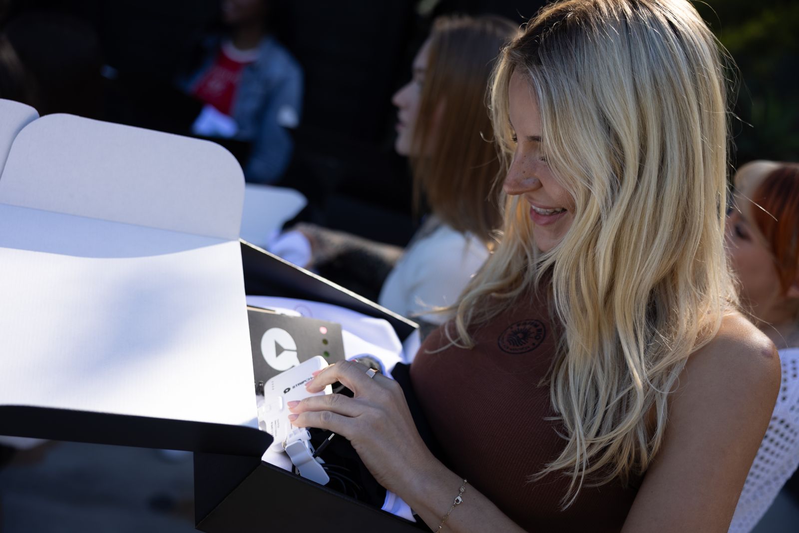 A cast member opens her Stripchat House welcome box on arrival day