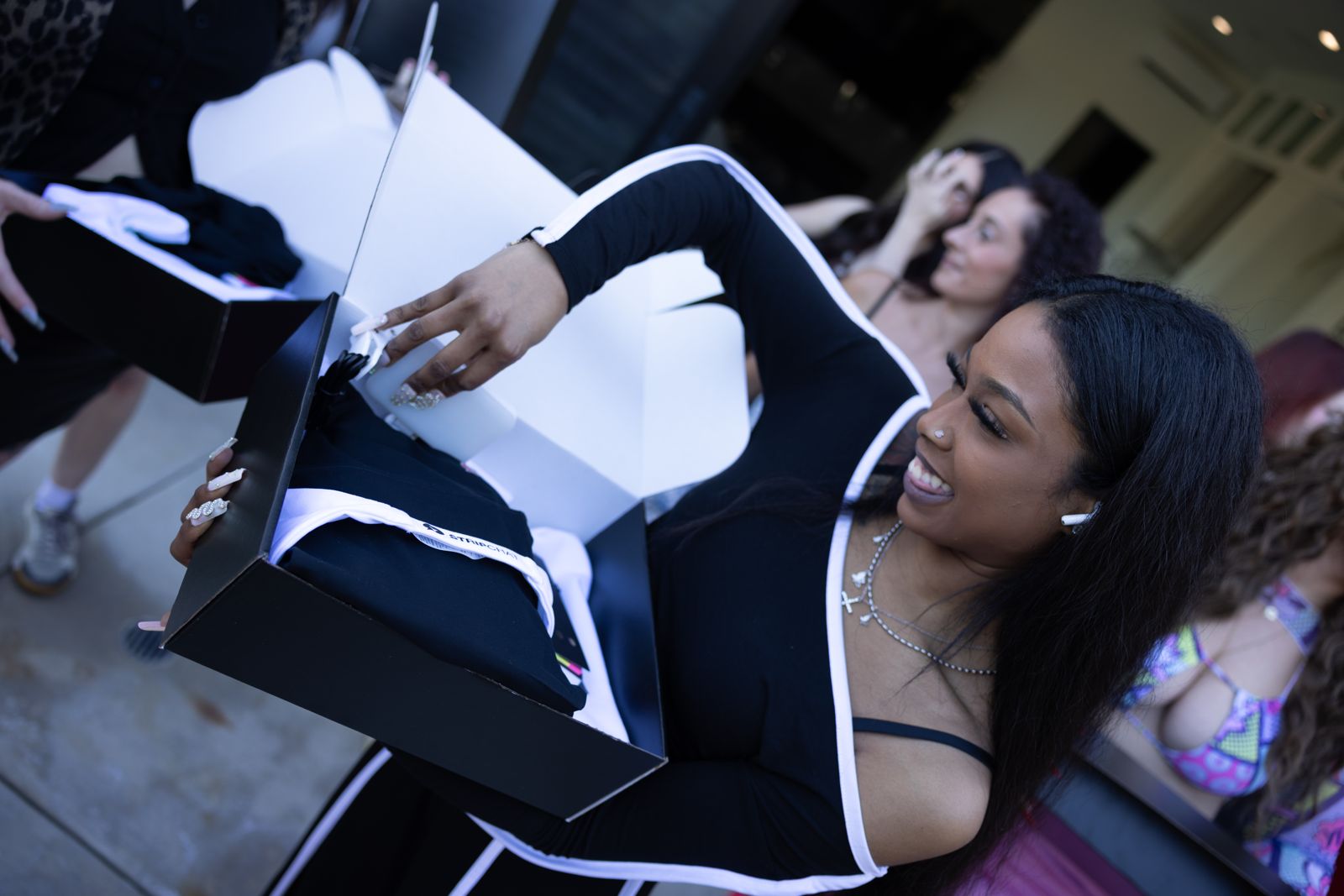 A cast member opens her Stripchat House welcome box on arrival day