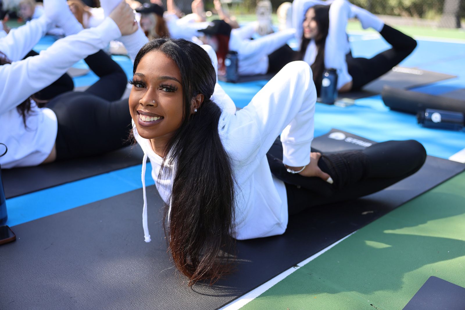 Goat yoga session on the pickleball court at the Stripchat House Hollywood, goats climbing on cast members' backs