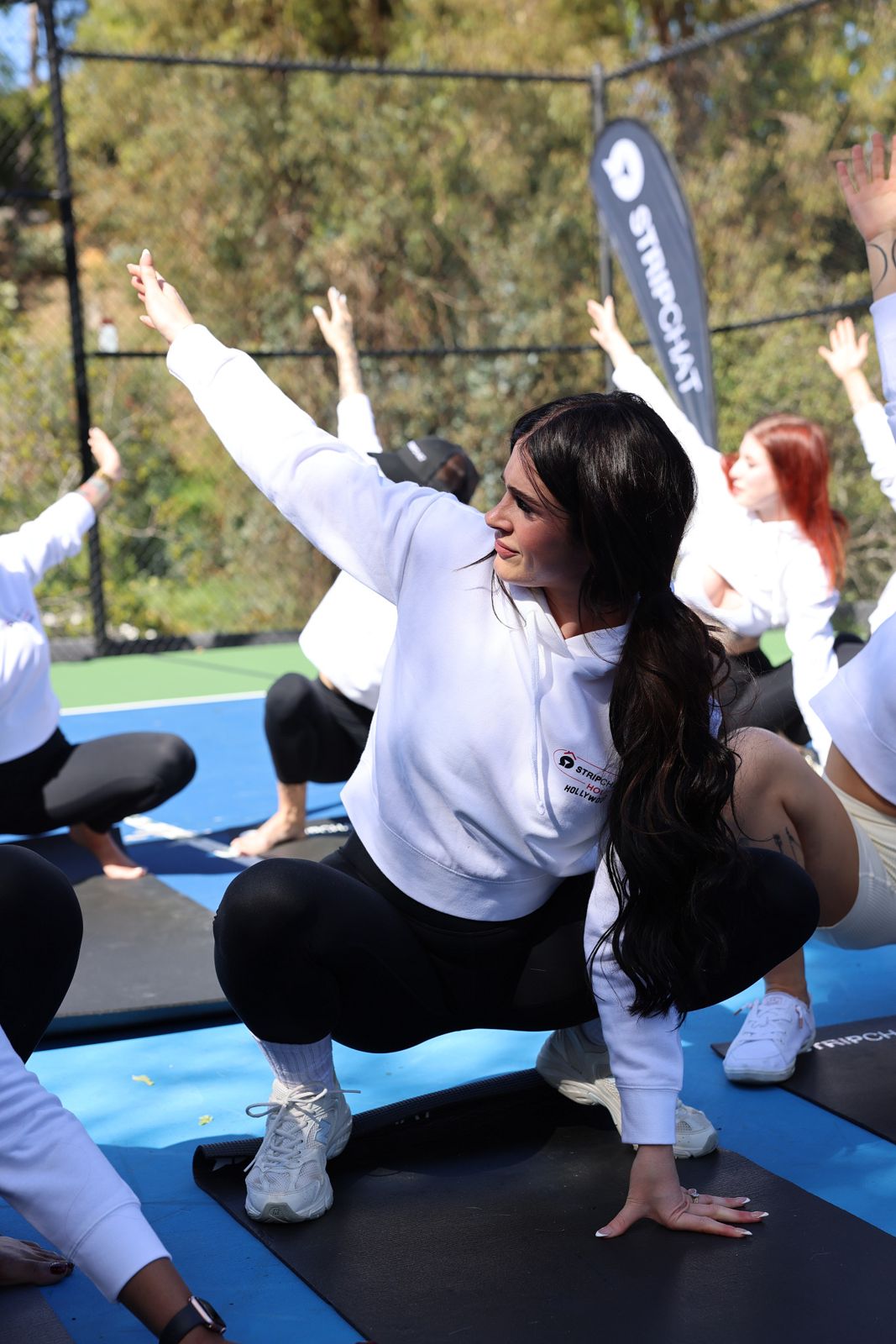 Goat yoga session on the pickleball court at the Stripchat House Hollywood, goats climbing on cast members' backs