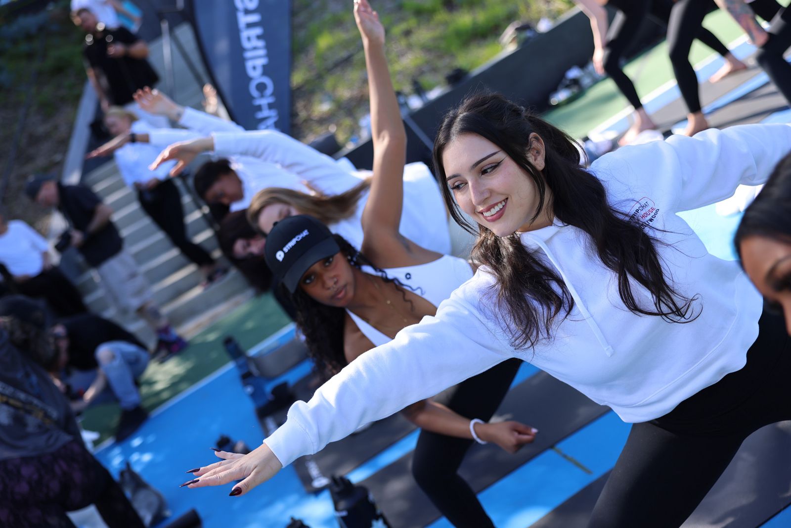 Goat yoga session on the pickleball court at the Stripchat House Hollywood, goats climbing on cast members' backs