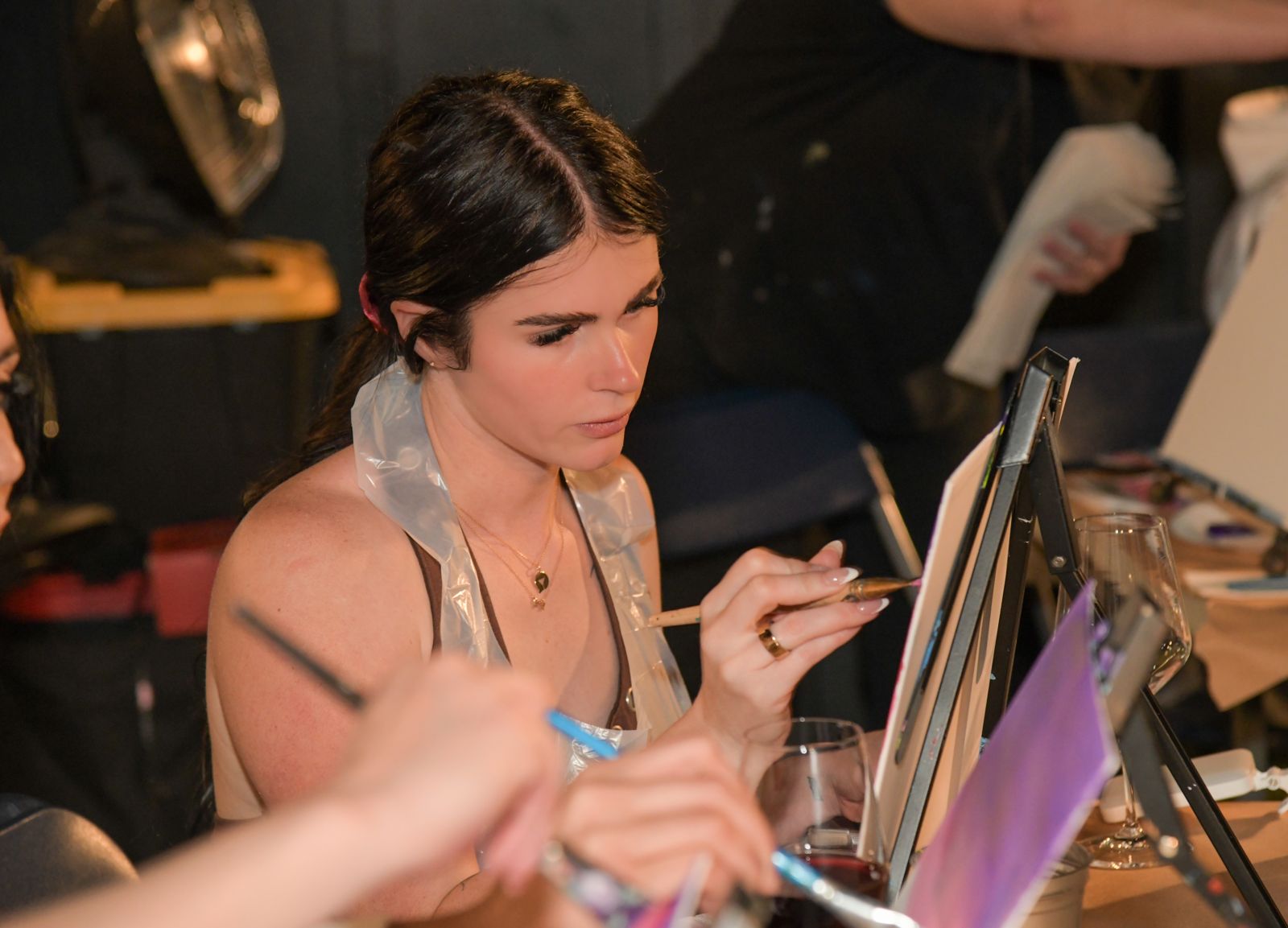 Cast members painting canvases at the evening sip and paint session at the Stripchat House