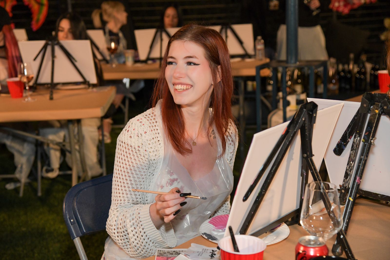 Cast members painting canvases at the evening sip and paint session at the Stripchat House
