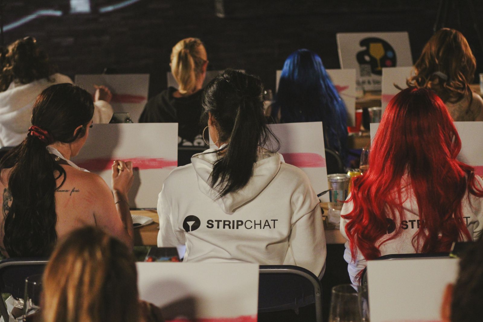 Cast members painting canvases at the evening sip and paint session at the Stripchat House