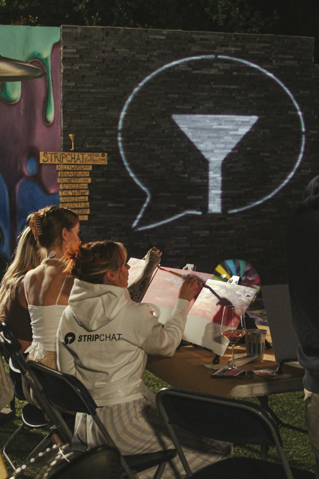 Cast members painting canvases at the evening sip and paint session at the Stripchat House
