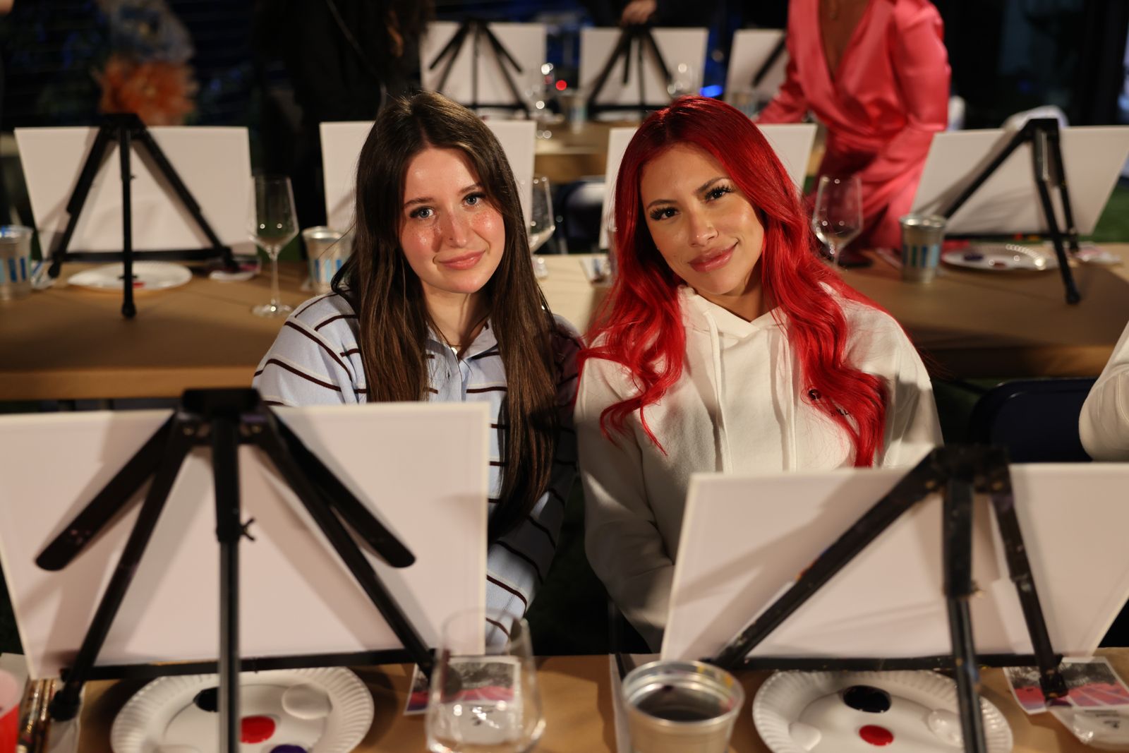 Cast members painting canvases at the evening sip and paint session at the Stripchat House