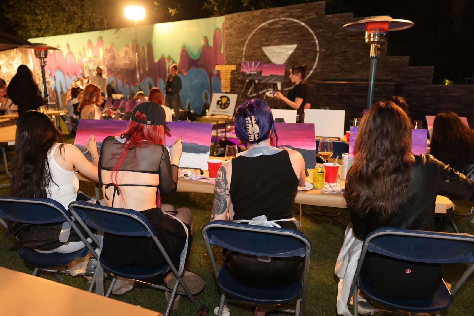 Cast members painting canvases at the evening sip and paint session at the Stripchat House