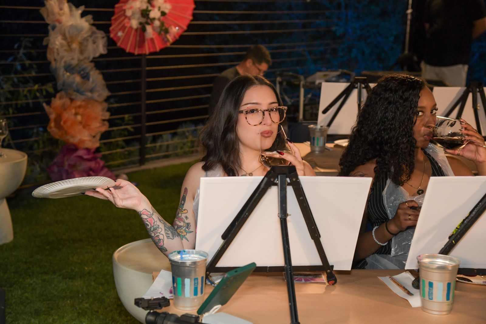 Cast members painting canvases at the evening sip and paint session at the Stripchat House