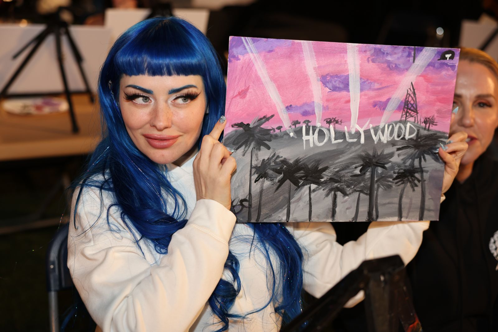 Cast members show off their finished Hollywood paintings at the Stripchat House sip and paint night