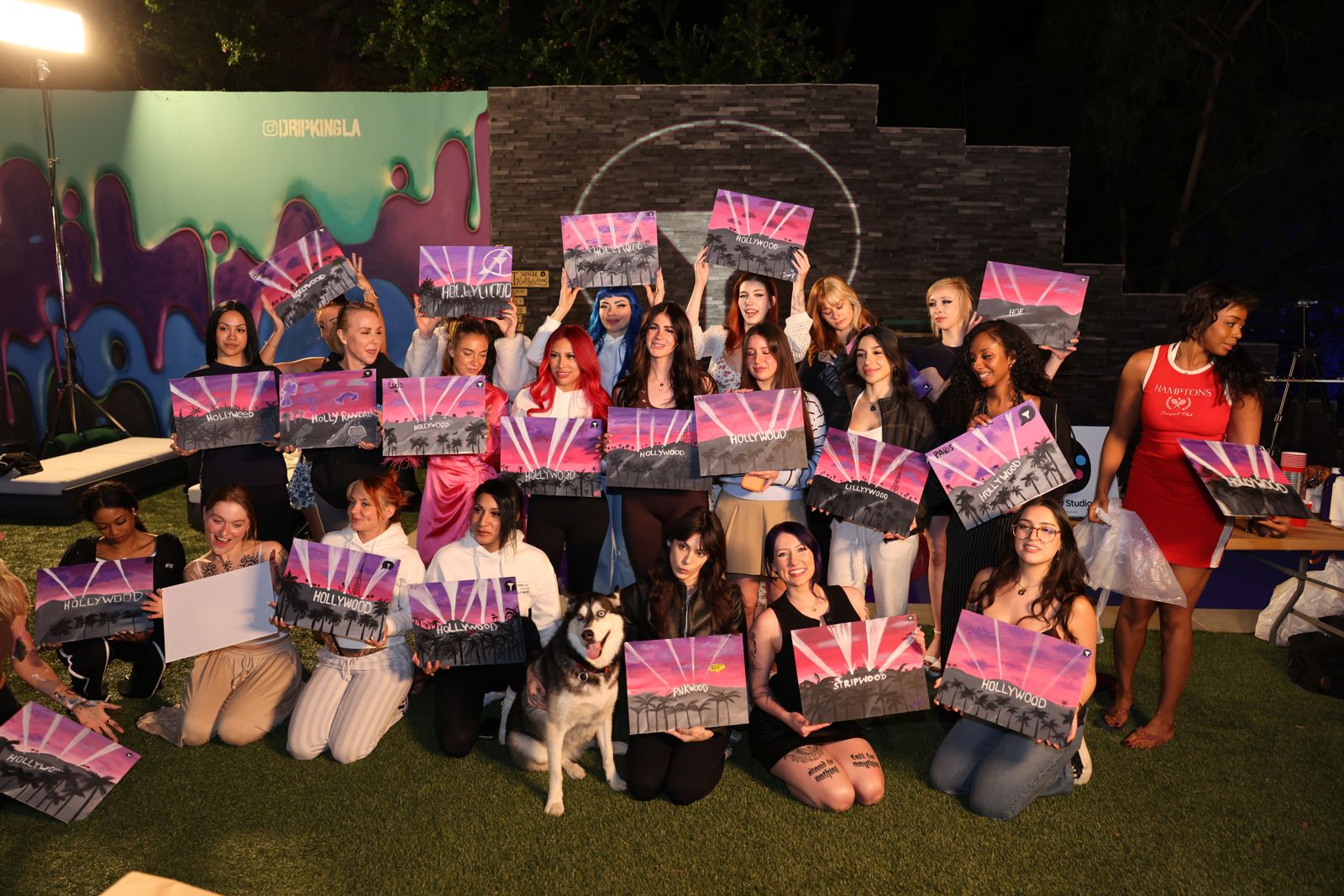 The whole cast holds up their finished Hollywood paintings at the Stripchat House sip and paint