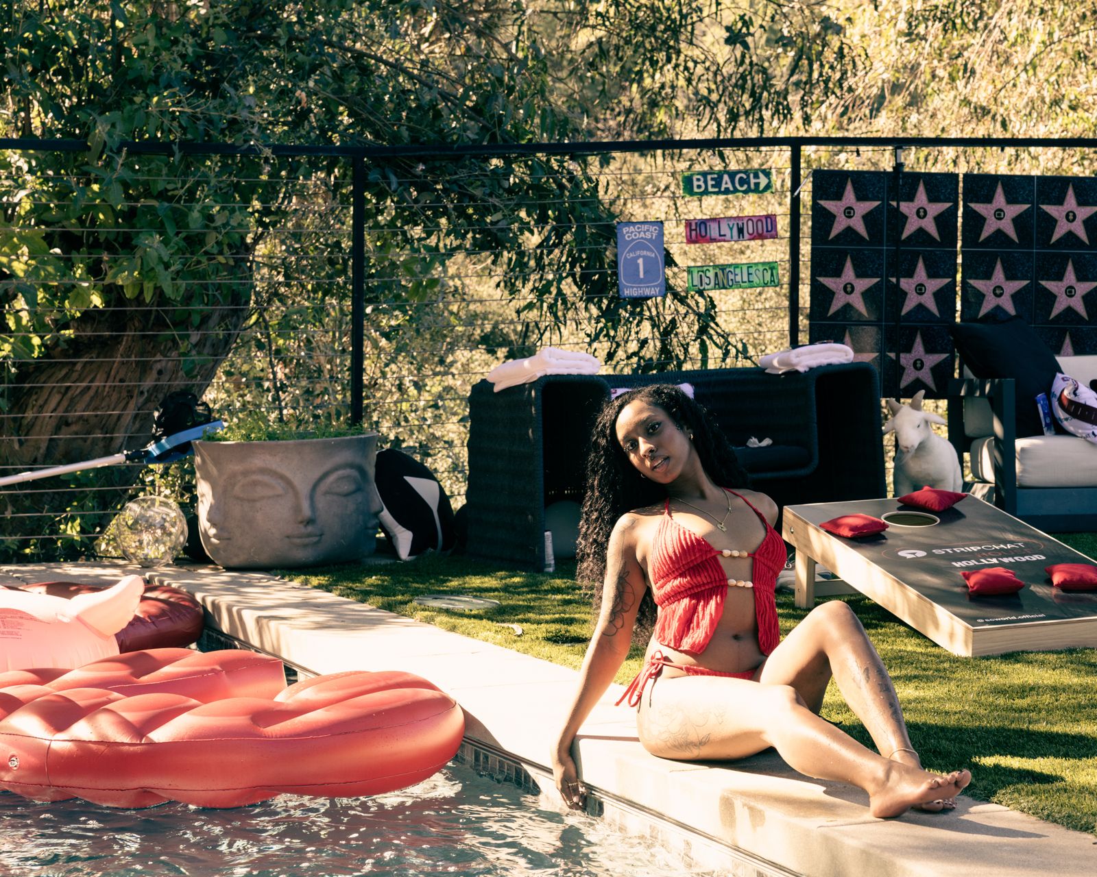 A cast member cools off in the pool at the Stripchat House Hollywood mansion