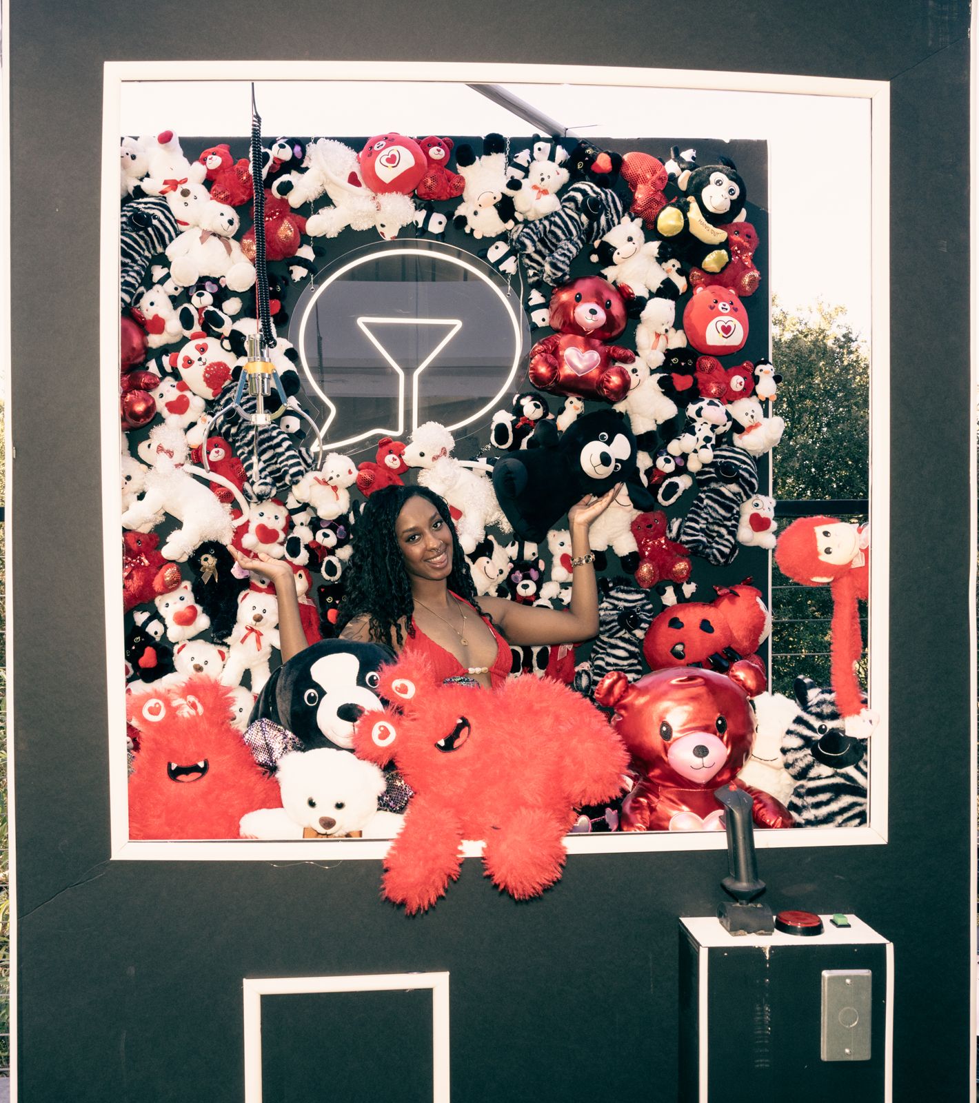 Posing at the teddy-bear claw-machine wall at the Stripchat House Hollywood