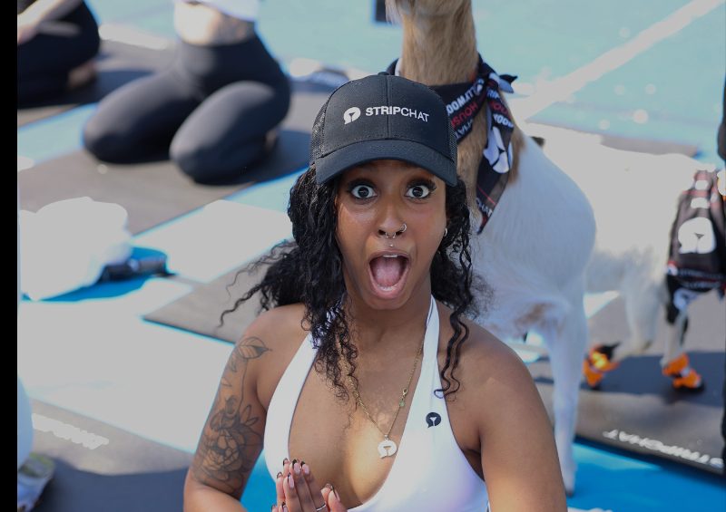 A cast member mid-pose reacting to the goat climbing onto her back